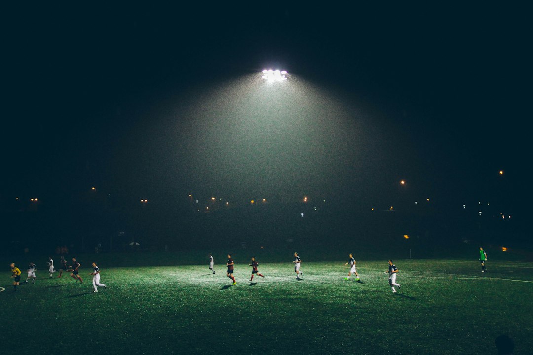 A floodlit football pitch at night, setting the mood for a Ted Lasso watch night
